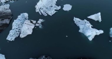 Ünlü Jokulsarlon Buzul Gölü 'ndeki buzdağları, Buzdağları üzerindeki AerialDrone manzarası ve Jokulsarlon gölü köprüsü, Şubat 2021  