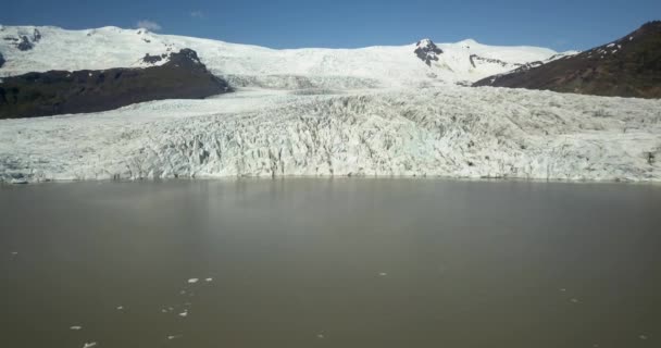 ヨーロッパの氷河ラグーンの上の空中ビュー黒い灰とFjallsrlnアイスランドの尾根 氷を溶かす 地球温暖化の概念2021年2月 — ストック動画