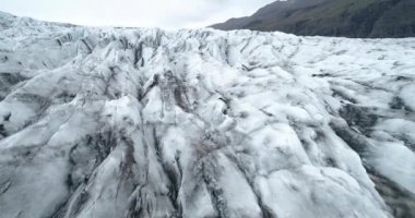 Avrupa 'daki buzul gölü Fjallsrln İzlanda Tepeleri üzerinde siyah külle birlikte hava manzarası. Eriyen buz. Küresel ısınma kavramı, Şubat 2021