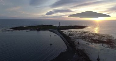 Uçan daireler filosu günbatımında ana gemi, hava manzarası ve deniz feneri manzarasına doğru ilerliyor.