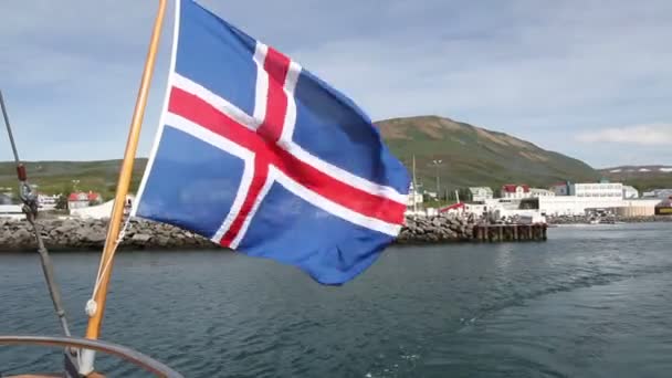 Båten lämnar Island Bay med flagga — Stockvideo