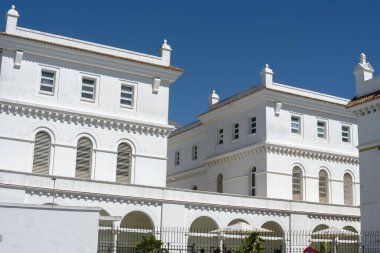 Photograph of the typical architecture of Cadiz, Andalusia, Spain. Historic buildings with white and pastel facades, wrought-iron balconies, and Mediterranean atmosphere. Perfect image for concepts of tourism, Spanish culture, and architectural herit