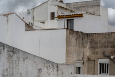 Cordoba 'nın beyaz ve kırmızı çatılarının manzaralı bir görüntüsü, arka planda şehrin silueti, geleneksel Endülüs mimarisini, dar sokakları ve bu tarihi İspanyol şehrinin eşsiz atmosferini yakalıyor.