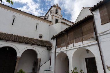 Beyazlatılmış duvarlar, çiçekli avlular, işlenmiş demir pencereler ve seramik dekorasyonlar içeren tipik Cordoba mimarisinin ayrıntıları Endülüs stili harmanlama Mağribi ve Akdeniz etkilerinin otantik bir örneği