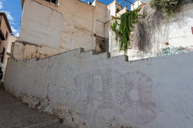 Characteristic narrow streets and traditional architecture of Granada, featuring white facades, decorated balconies, and winding alleys in the historic center. Perfect image for tourism, culture, travel, and Andalusian architecture projects.