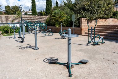 View of a gym or fitness area in Granada, Spain, featuring exercise equipment, weights, and machines. Perfect image for concepts of sports, physical activity, wellness, healthy lifestyle, workout, and leisure.