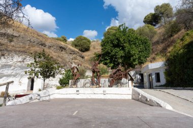 View of a walking path in the Cuevas del Sacromonte Museum in Granada, featuring traditional caves carved into the rock, typical of Andalusian architecture. Perfect image for concepts of culture, history, tourism, travel, and Spanish heritage.