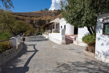 View of a walking path in the Cuevas del Sacromonte Museum in Granada, featuring traditional caves carved into the rock, typical of Andalusian architecture. Perfect image for concepts of culture, history, tourism, travel, and Spanish heritage.