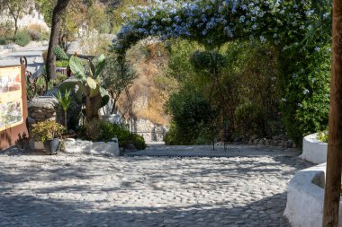 View of a walking path in the Cuevas del Sacromonte Museum in Granada, featuring traditional caves carved into the rock, typical of Andalusian architecture. Perfect image for concepts of culture, history, tourism, travel, and Spanish heritage.