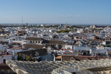 İspanya 'nın Sevilla kentinin hava manzarasında tipik Endülüs binaları, kırmızı çatılar ve tarihi merkezin dar sokakları yer alıyor. Şehir panoraması yukarıdan şehrin güzelliğini gösteriyor.