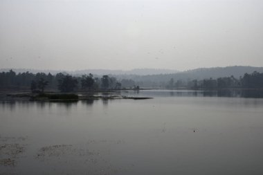 Güzel Khadarani gölü ve dağı Jhargram, Batı Bengal, Hindistan 'da sabahın erken saatlerinde sisli ve siyah beyaz.