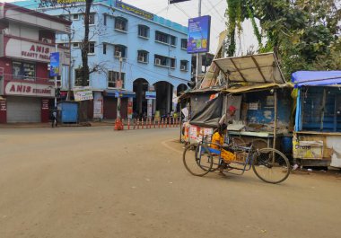 Jhargram, Batı Bengal, Hindistan - 7 Şubat 2021: Tekerlekli sandalyedeki engelli çocuk diğer insanlar gibi karşıdan karşıya geçiyor. İnsan konseptinin engelliliği.