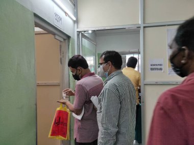 Jhargram, Batı Bengal, Hindistan - 23 Şubat 2021: Genel Kurul Seçim 2021 anket personeli Jhargram Hastanesi 'nde aşı sürüşü sırasında Covid-19 koronavirüs aşısı için sırada bekliyor.