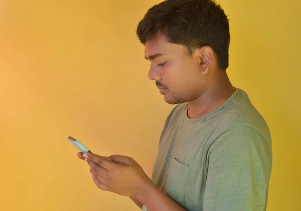 若いですインド人男性見ます彼の携帯電話使用時に自宅でインターネット時Covid 19ペンダントロックダウン — ストック写真