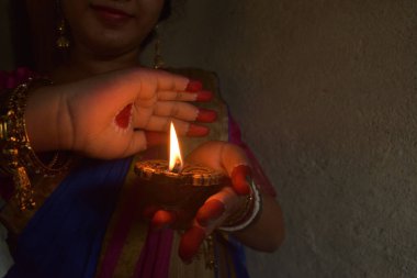 Hintli bir kadın lamba yakar ve Diwali ya da Deepavali festivalini kutlardı. Geleneksel Hinduizm uygulaması kavramı. Lambaya odaklan..