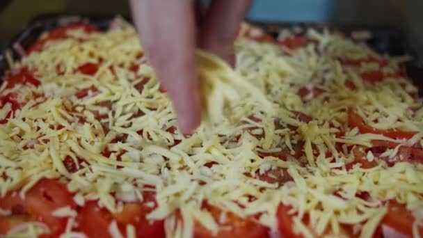 Mann bestreut hausgemachte Pizza mit Käse aus nächster Nähe — Stockvideo