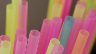 Plastik renkli kokteyl tüpleri, yakın plan, kamera hareketi, raf odaklı.