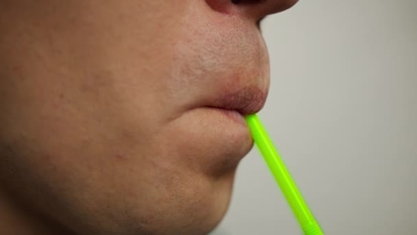 Närbild mans läppar dricka en drink från en plast cocktail tube — Stockvideo