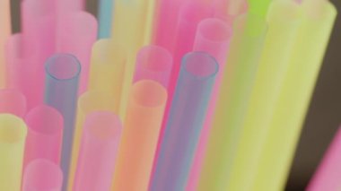 Plastik renkli kokteyl tüpleri, yakın çekim, kamera hareketi, rafa odaklanma.