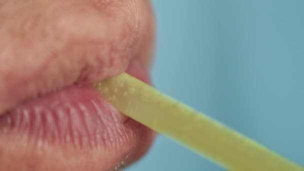 Bibir seorang pria dengan sedotan, minum minuman, close-up — Stok Video