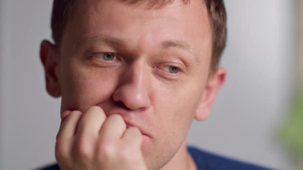 Porträtt av en ung man som sitter vilse i tanken, närbild — Stockvideo