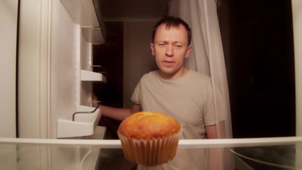 Refrigerador de un joven solitario, un cupcake estropeado en el estante — Vídeos de Stock