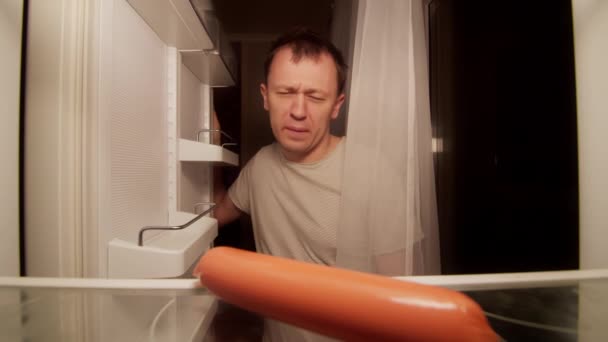 Bekar bir adamın buzdolabında bozulmuş bir sosis var. — Stok video