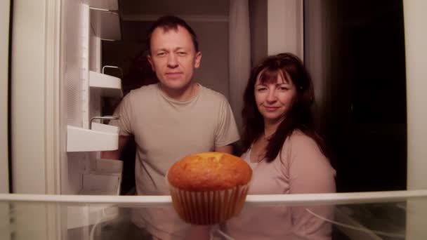 Женатая пара открывает холодильник ночью и находит там один испорченный кекс — стоковое видео