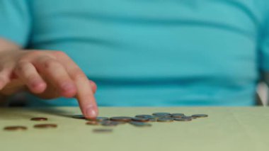 Masada oturan adam para sayıyor, yakın plan.