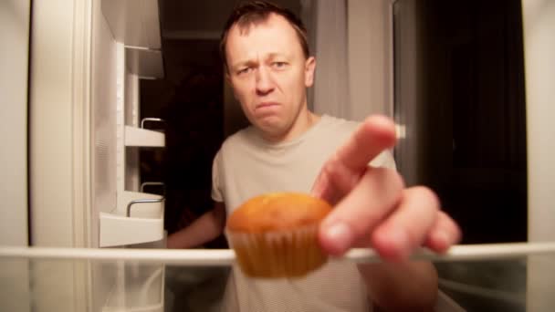 Głodny człowiek znajduje zepsute babeczki w lodówce w nocy — Wideo stockowe