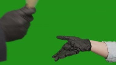 Eldivenli bir adam bir kadına bir tomar para veriyor, kroma anahtarı.