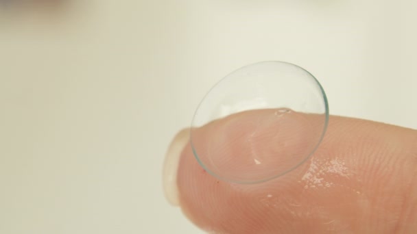 Old soft contact lens on a womans finger, close-up — Stock Video