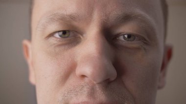 Yeşil gözlü genç bir adamın portresi. Yakından kameraya bakıyor.