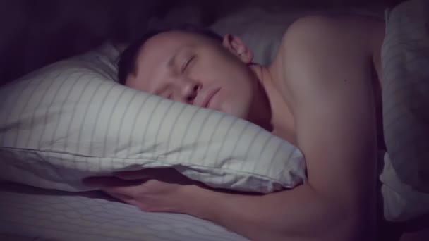 若い男は夜にベッドに行き、すぐに眠りに落ちる — ストック動画