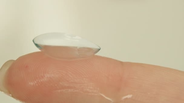 Vrouwelijke vinger met zachte contactlens, close-up — Stockvideo