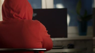 Evde bilgisayar başında çalışan genç bir erkek programcı.
