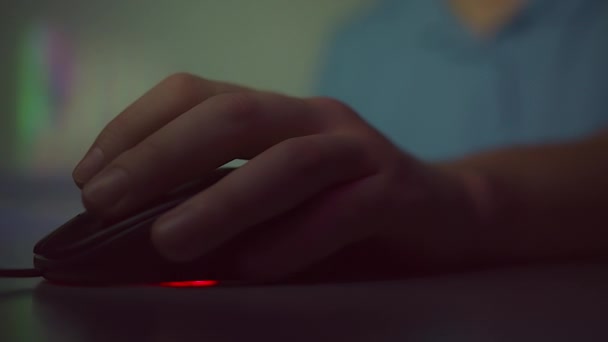 Κοντινό πλάνο ενός χεριού mans, που εργάζονται σε έναν υπολογιστή, κλικ στα κουμπιά ενός ποντικιού υπολογιστή και γυρίζει έναν πάπυρο. Φως το βράδυ — Αρχείο Βίντεο