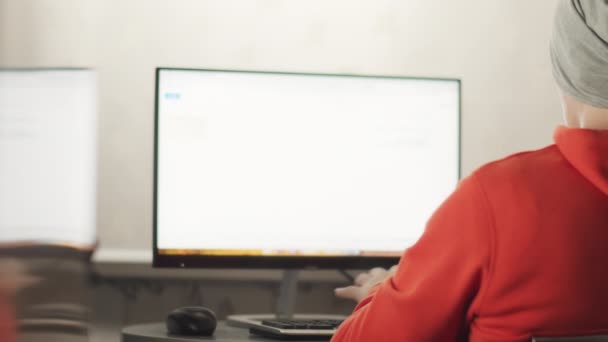 Egy szürke kalapos férfi számítógépen dolgozik, tükröződik a falon, távoli munka, szöveges hely. — Stock videók