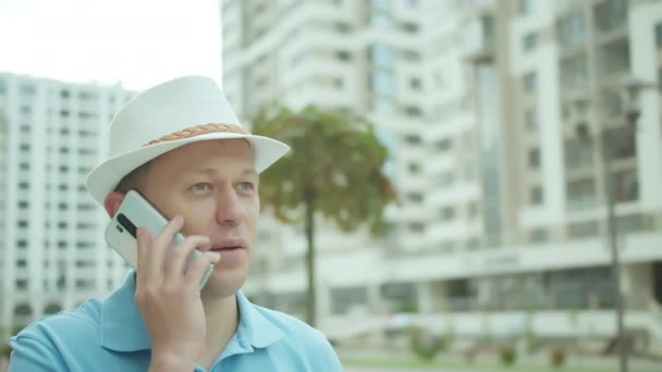 Muž Klobouku Mluví Mobilním Telefonu Zatímco Stojí Pozadí Budov — Stock video
