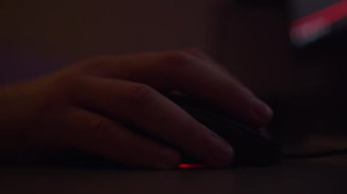 Bir bilgisayar faresi, akşamları monitörün arkasında çalışır, monitör ekranının arka ışığı...
