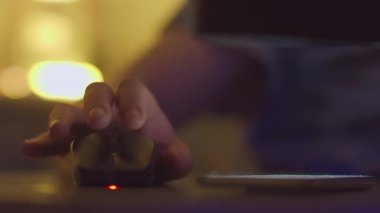 Akşamları bilgisayar başında çalışan bir adam bilgisayar faresi aracılığıyla telefon mesajlarına cevap verir.