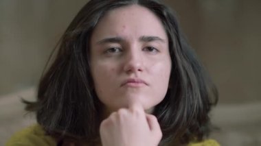 Genç bir kızın doğrudan kameraya bakması, yakın plan.