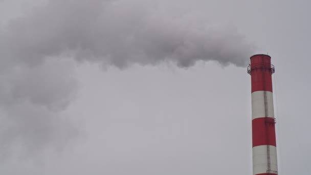 Working industrial pipe, against a gray sky, air pollution — Stok video