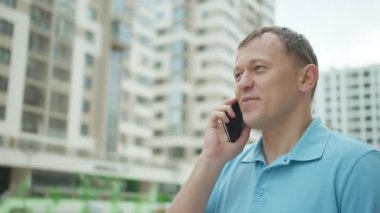 Portrait of a young man talking on a mobile phone while standing on a city street