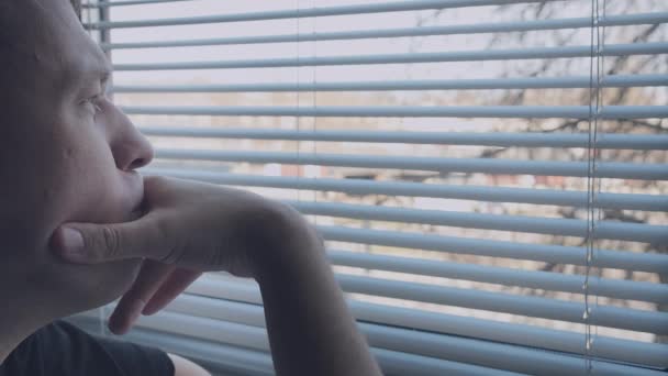 Скучный человек смотрит в окно — стоковое видео