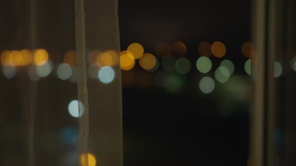 Fondo borroso de ventana de noche con luces de la ciudad con cortina — Vídeos de Stock