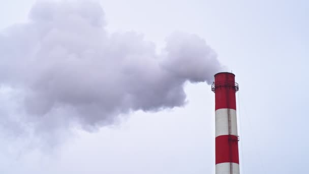 Arriba de una chimenea industrial con humo saliendo de ella, espacio para copiar, cielo gris — Vídeo de stock