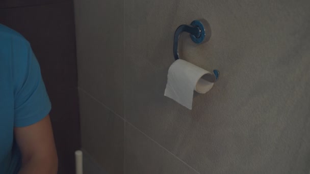 Ένας άντρας κάθεται στην τουαλέτα, με προβλήματα υγείας. Δεν υπάρχει χαρτί τουαλέτας. — Αρχείο Βίντεο