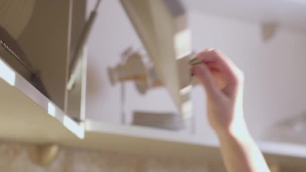 La mano femenina toma una placa del armario de la cocina, primer plano, rastreo de la cámara — Vídeos de Stock