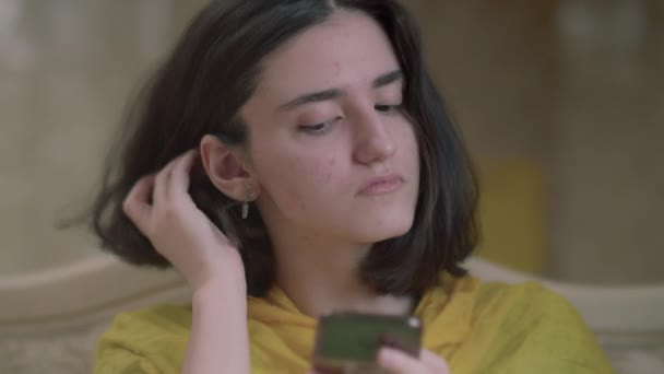 Porträtt av en tonåring flicka med brunt hår med en mobiltelefon — Stockvideo